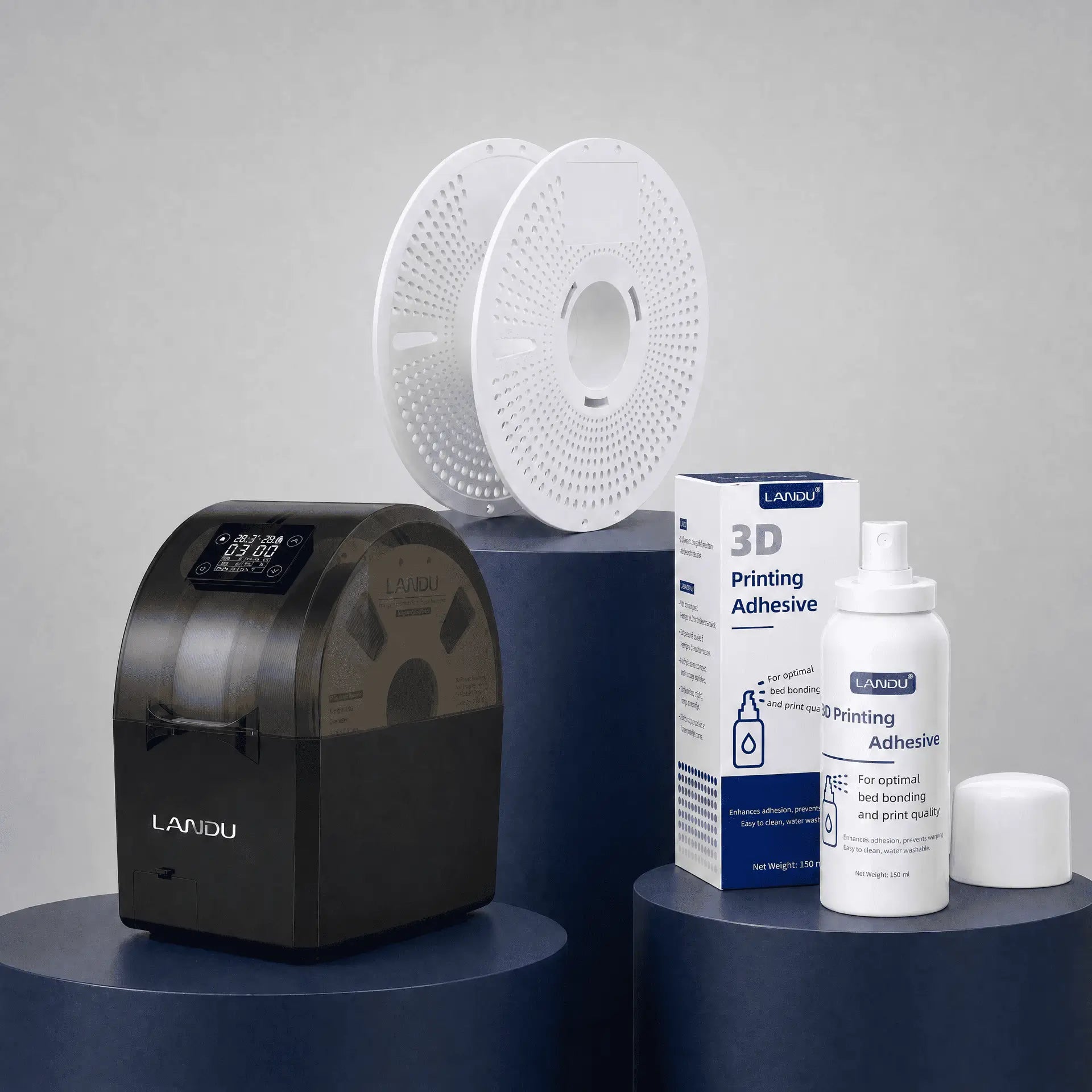 LANDU 3D printing accessories collection featuring a white refillable spool, a digital filament dryer box, and a bottle of bed adhesion spray.