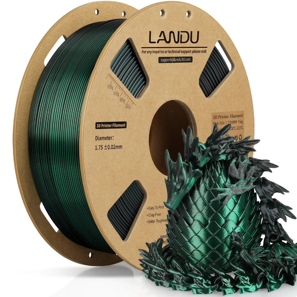 LANDU Black and Green Dual Color Silk PLA 3D printer filament 1kg spool alongside a highly reflective 3D printed color shifting dragon and egg.