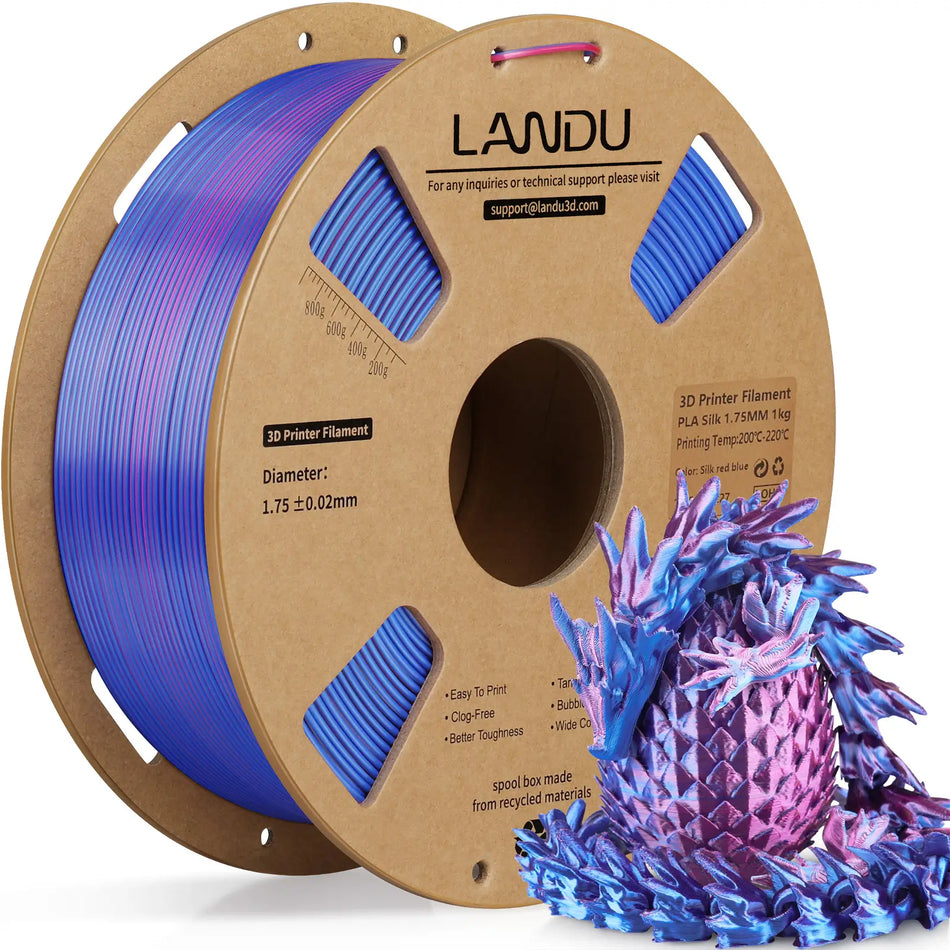 LANDU Red and Blue Dual Color Silk PLA 3D printer filament 1kg spool next to a glossy 3D printed color shifting dragon and egg.